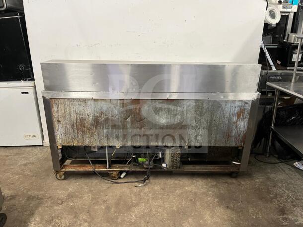 LEADER NSFM72 72" three-door refrigerated prep table for sandwiches and salads, signs of wear, on casters.