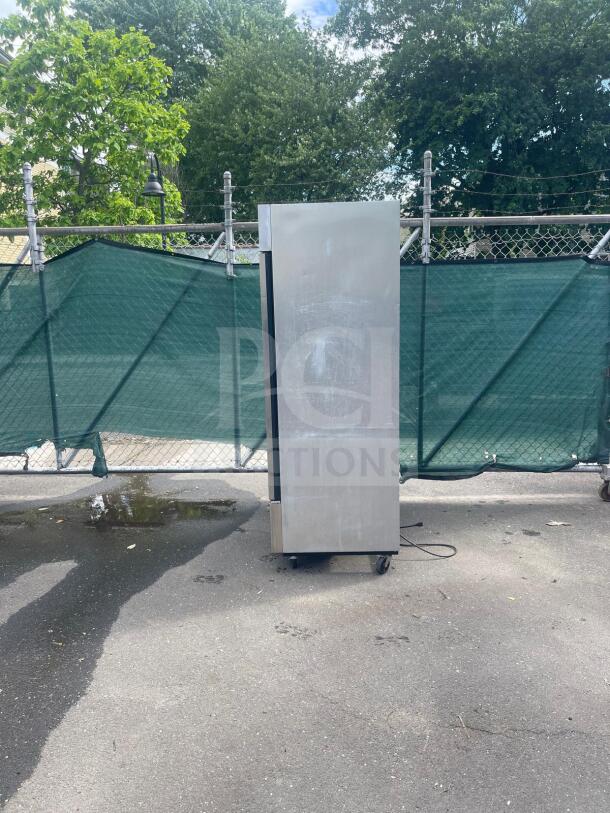 TRUE T-49-HC 54" two-section reach-in refrigerator, solid doors, left/right hinge, exterior wear, 115v, outdoors on casters.