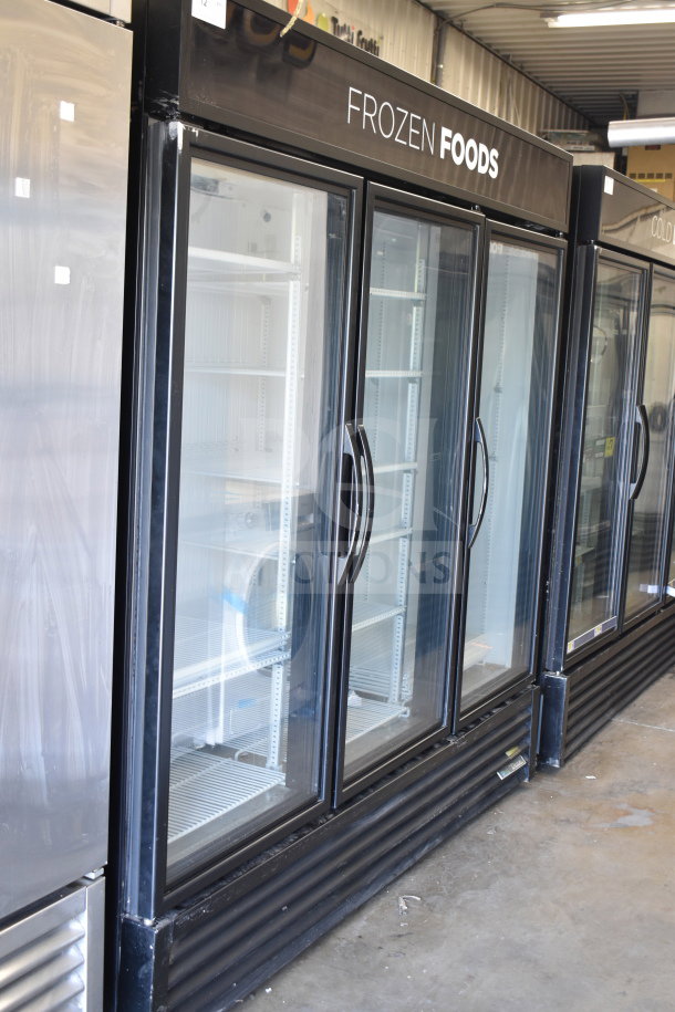 2017 True GDM-72F-HC commercial 3-door freezer merchandiser. Glossy black frame, glass doors, "Frozen Foods" label.