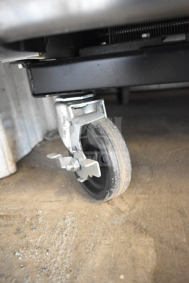 Close-up of a commercial caster on the 2021 True T-23-2-HC cooler, showing its sturdy design and mobility features.