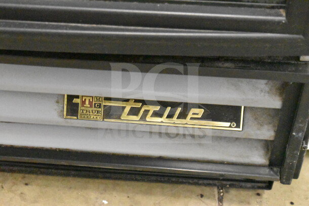 True GDM-12-LD single door cooler, 115 volts, visible True branding. Ideal for retail, sturdy design.