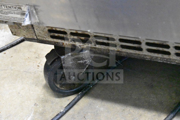 Everest EPBR2 prep table caster and base, showing wear and grime, indicating heavy use.