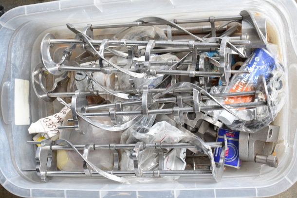 Two bins of various ice cream machine parts including augers, shown in a clear plastic container, parts appear in used condition.