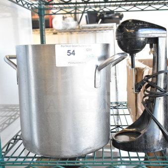 Alt text: Large stainless steel stock pot with handles and ST789 black milkshake mixer on metal shelf, auction label visible.