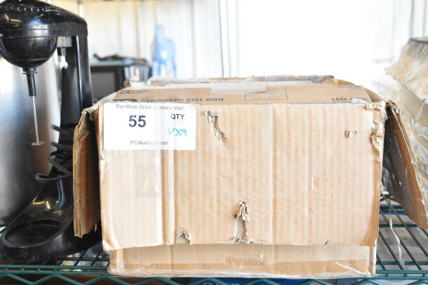 Cardboard box with label indicating 9 items, including an LED exit sign. Text reads "55 QTY 9x9." Box shows signs of wear.