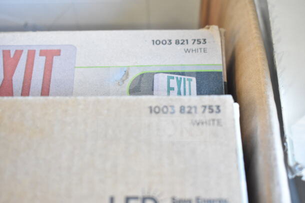 Auction box containing nine items including an LED exit sign, labeled "1003 821 753 WHITE."