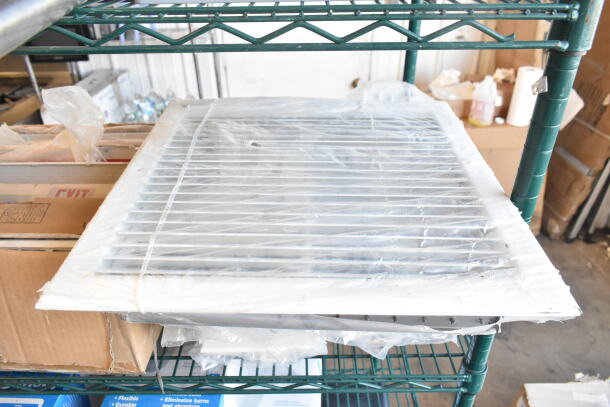 Stack of 10 various vent covers wrapped in plastic, new condition, on a metal shelf in a warehouse.