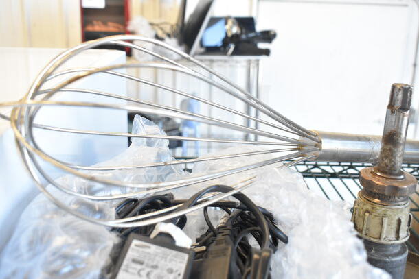 Lot including a large metal whisk, two pelican head blades, and a flat beater mixer attachment. Visible cords, used condition.
