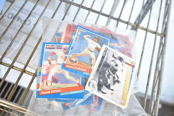 Lot of baseball cards featuring players like Frank DiPino and Mark Portugal, in protective sleeves, mixed condition.