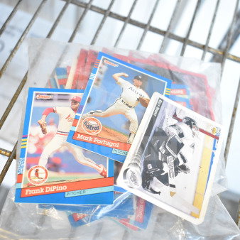 Lot of baseball cards featuring players like Frank DiPino and Mark Portugal, in protective sleeves, mixed condition.