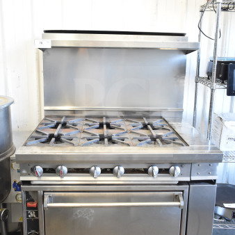 Jade Range commercial gas 6-burner range with oven, over shelf, back splash, and commercial casters; in good condition.