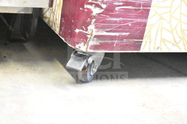 SD-575K Commercial Chest Freezer on casters, 115V, 1 Phase. Visible wear on exterior with functional commercial wheels.