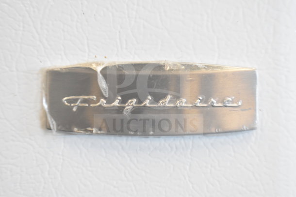 Frigidaire nameplate on FRT18HS6JW1 Reach In Cooler. Silver and embossed logo under protective plastic.
