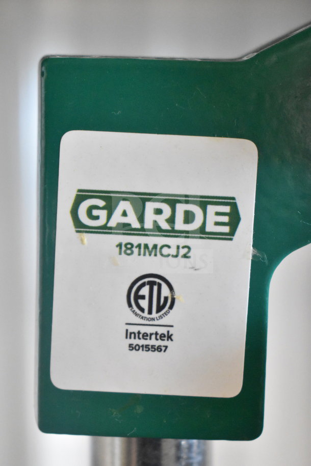 "Brand new Garde 181MCJ2 manual citrus juicer with safety spring; ETL listed, some scratches visible on label."