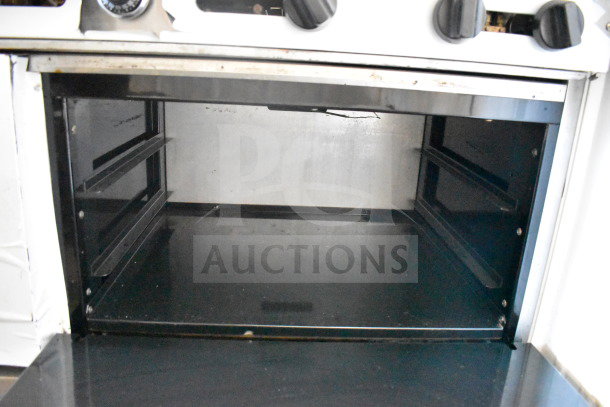 American Range commercial gas-powered 6 burner range with oven and backsplash; features visible oven interior in good condition.