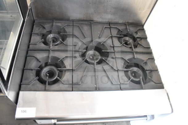 American Range commercial gas-powered 6 burner range with oven and backsplash. Stainless steel body, good condition.