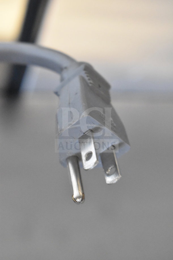 Close-up of a Master-Bilt UF27 freezer power plug, showing a standard three-prong 115V plug.