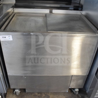 H&K 52473-1 commercial chest freezer, stainless steel, 120 volts, 1 phase, mounted on wheels, auction tag visible.