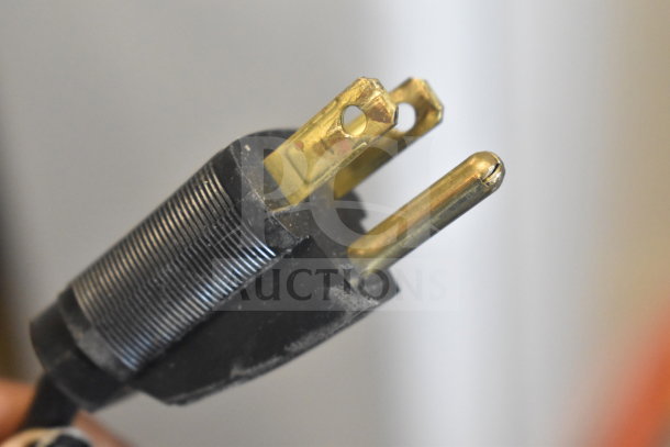 Close-up of a three-prong electrical plug for the Hobart HTi-7LH26 scale, indicating voltage compatibility.