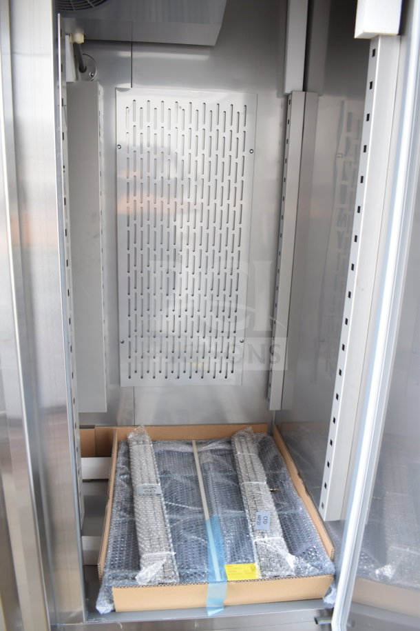Brand new Avantco 178SS2FHC commercial freezer interior, showing shelving in packaging. Two-door unit on casters, 115V, 1 Phase.