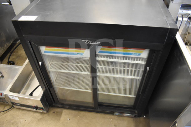 2021 True GDM-09-SQ-HC-LD 2-door reach-in cooler merchandiser, black, with glass doors and interior shelves, used condition.