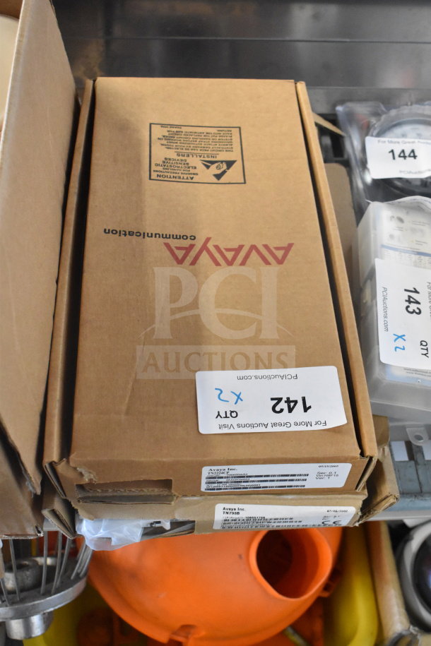 Two Avaya circuit board boxes labeled with bid information and quantity, indicating auction item. Boxes appear in good condition.