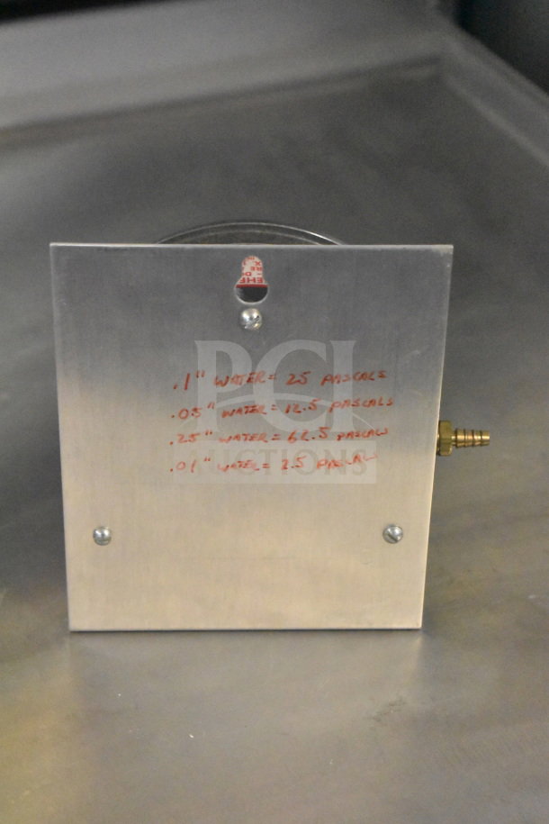Metal gauge with handwritten calibrations showing water to pascal conversions. Durable build, some visible markings.
