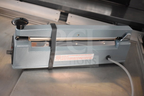 American International Electric AIE-305 impulse sealer, 220 volts, metal construction, caution label visible on body.