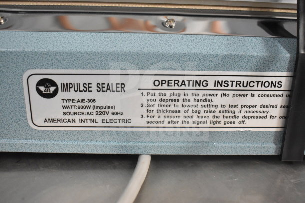 American International Electric AIE-305 Impulse Sealer, 600W, 220V. Features instruction label with operating guidelines.