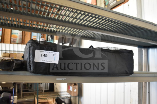 Black bag with a tag labeled "149" from PCI Auctions, in good condition on a metal shelf.