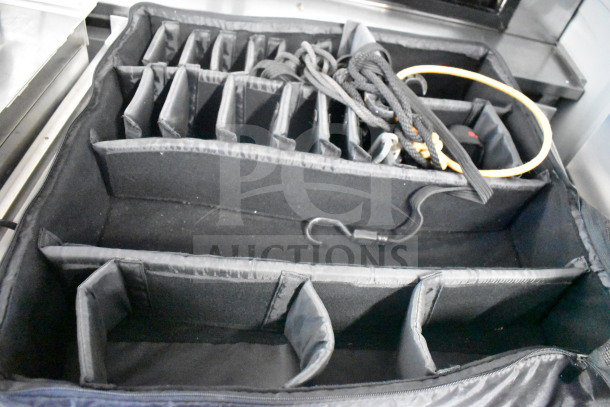 Black bag with multiple compartments, adjustable dividers, and assorted cords. Appears in good condition, ideal for organizing.