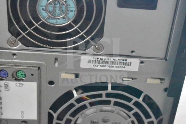 Back of a computer tower with visible serial number: CCP13025999189004. Includes fan and PS/2 ports.