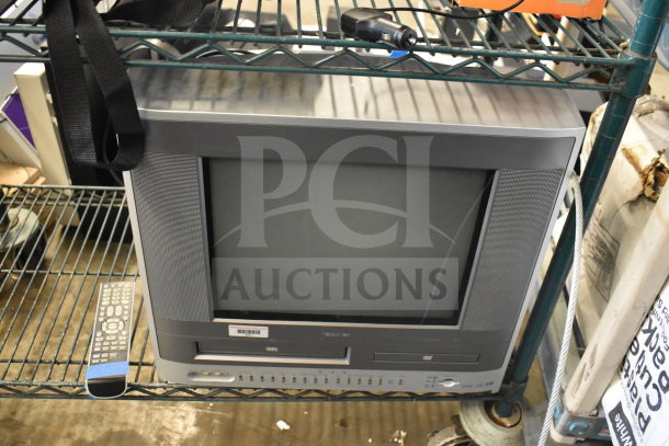 Toshiba MW14F51 monitor with VHS/DVD, black remote beside it, in good condition on metal shelving.