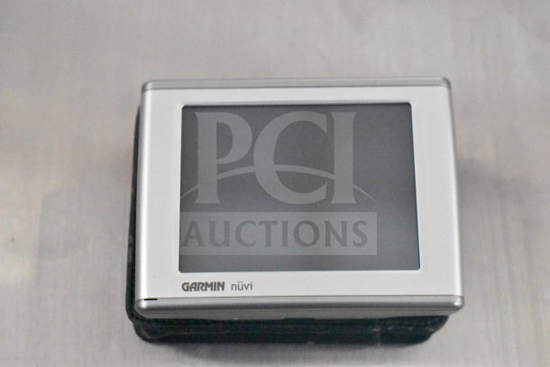 Garmin Nuvi GPS device, silver frame, brand label visible. Appears in used condition. Part of lot with cameras and bags.