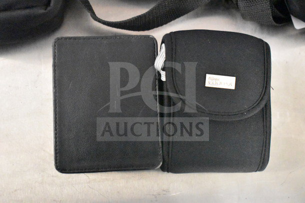 Two black camera bags, one labeled "Nikon Coolpix," on a surface. Part of a set with 9 bags and 2 cameras.
