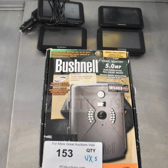 Five items including four Garmin GPS units and a Bushnell Trail Sentry 5.0 MP digital trail camera, boxed, visible auction tag.