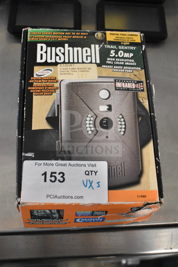 Boxed Bushnell Trail Sentry digital trail camera, 5.0MP, infrared night vision, alongside four Garmin GPS devices.