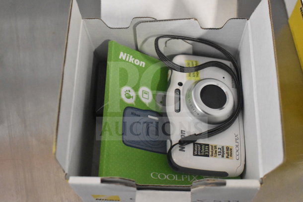 Nikon Coolpix S32 digital camera in original box, includes manual and wrist strap, new condition.