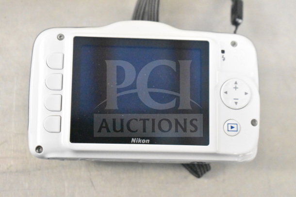 Nikon Coolpix S32 digital camera, white, rear view with screen and controls visible. Includes original box.
