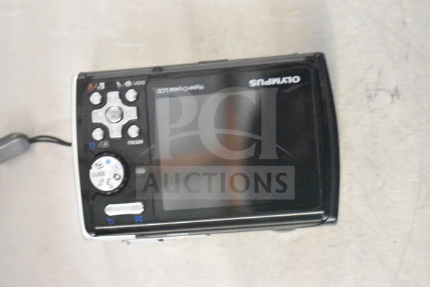 Three Olympus Stylus 850 SW digital cameras in original box, features durable design, various control buttons, appears in good condition.