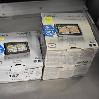 Three Garmin GPS devices in original boxes, including Nuvi 1350 and Nuvi 1390 models, featuring free lifetime maps.