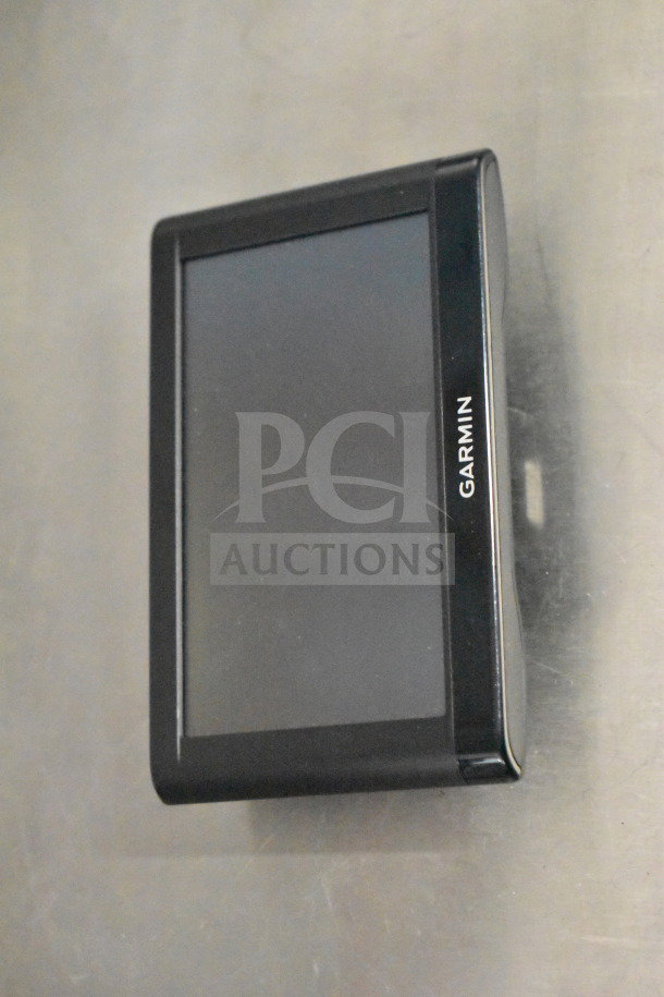 Garmin GPS device in black casing, possibly Nuvi 1350 or 1390, with visible screen. Original box mentioned.