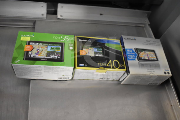 Three Garmin GPS units in original boxes: Nuvi 55 LM, Nuvi 40 LM, and Nuvi 1350 LM. Includes free lifetime maps.