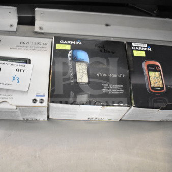 Three Garmin GPS devices in original boxes: eTrex Legend H, eTrex 20, Nuvi 1390LMT. Auction tag indicates triple bid value.