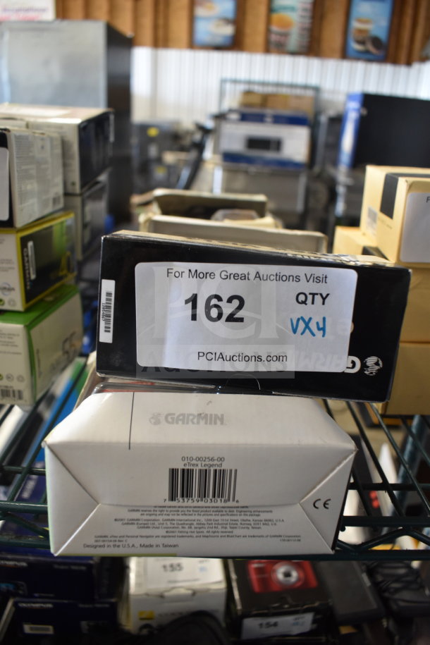 Boxed Garmin GPS units, including 76 Marine Navigator and eTrex Legend. Auction box labeled "162 QTY VX4".