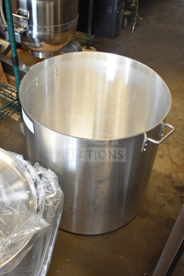 Heavy weight aluminum stock pot with handles, visible plastic wrap, showing potential scratch and dent condition.