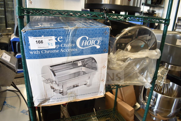 Two brand new Choice Deluxe 8 Qt. Roll Top Chafers, with chrome accents, in original packaging, slight box wear visible.