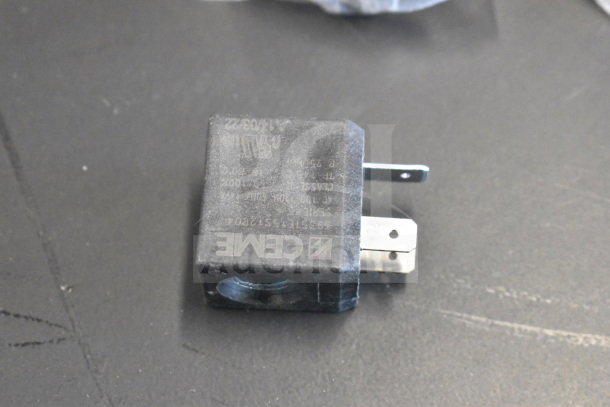Black electrical component block with prongs, showing markings. Item appears new, suitable for industrial use.