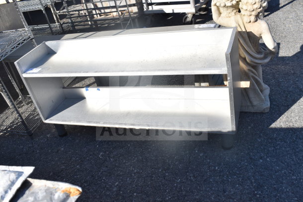 Commercial 2 Tier Shelf, metal, used condition, visible scratches and scuffs, suitable for storage or display.