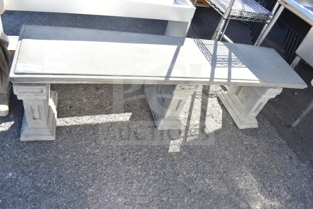 Stone bench with decorative pedestal legs, outdoor setting; visible item tag numbered 193, in good condition.